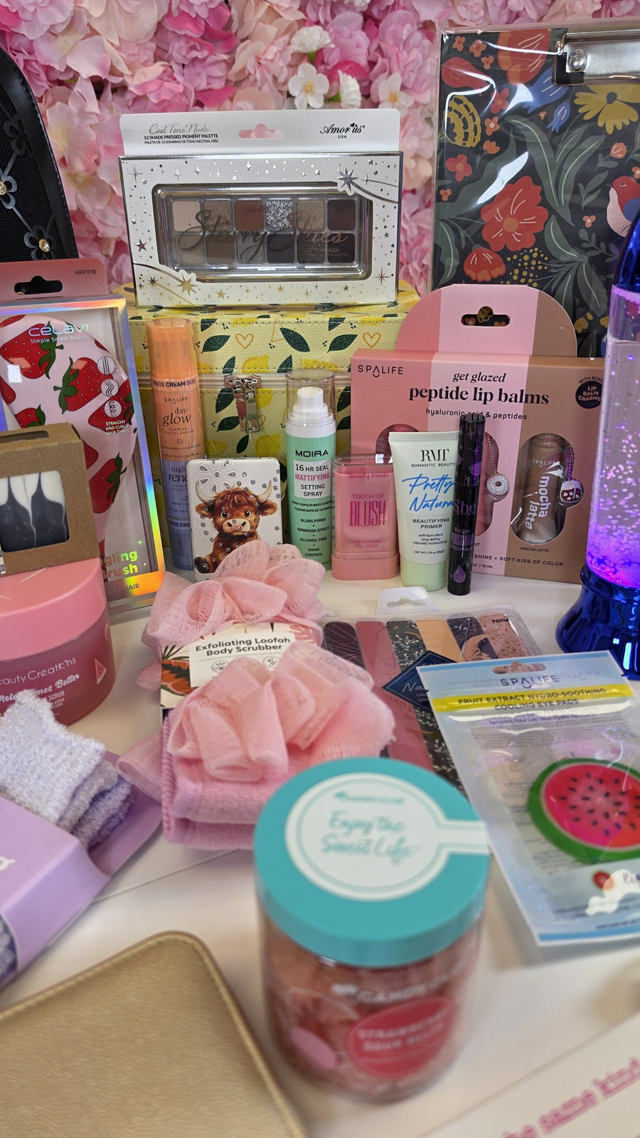 Eyeshadow palette, lip balms, primer, setting spray, loofahs and eye pads